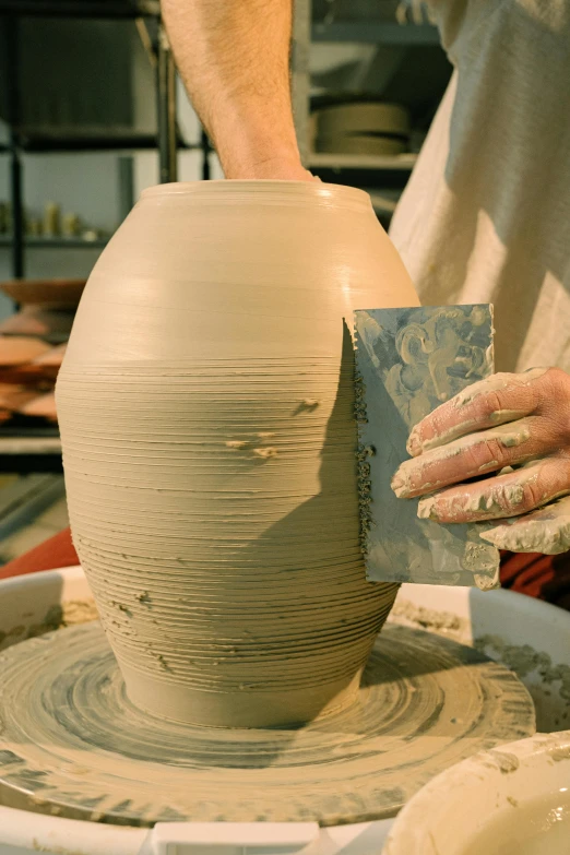 a man is making a vase out of clay, inspired by Hendrik Gerritsz Pot, holding a tower shield, straya, thumbnail, large tall