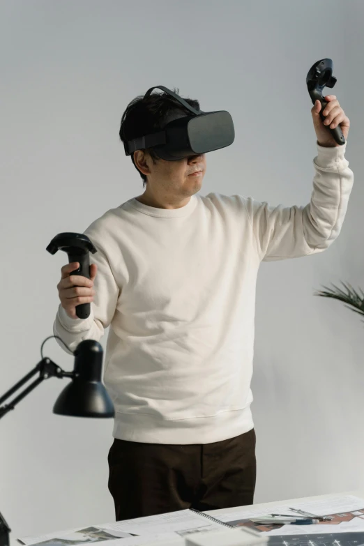 a man standing in front of a desk holding a remote control, inspired by Raymond Han, oculus quest 2, asian male, “hyper realistic, cybertech wear