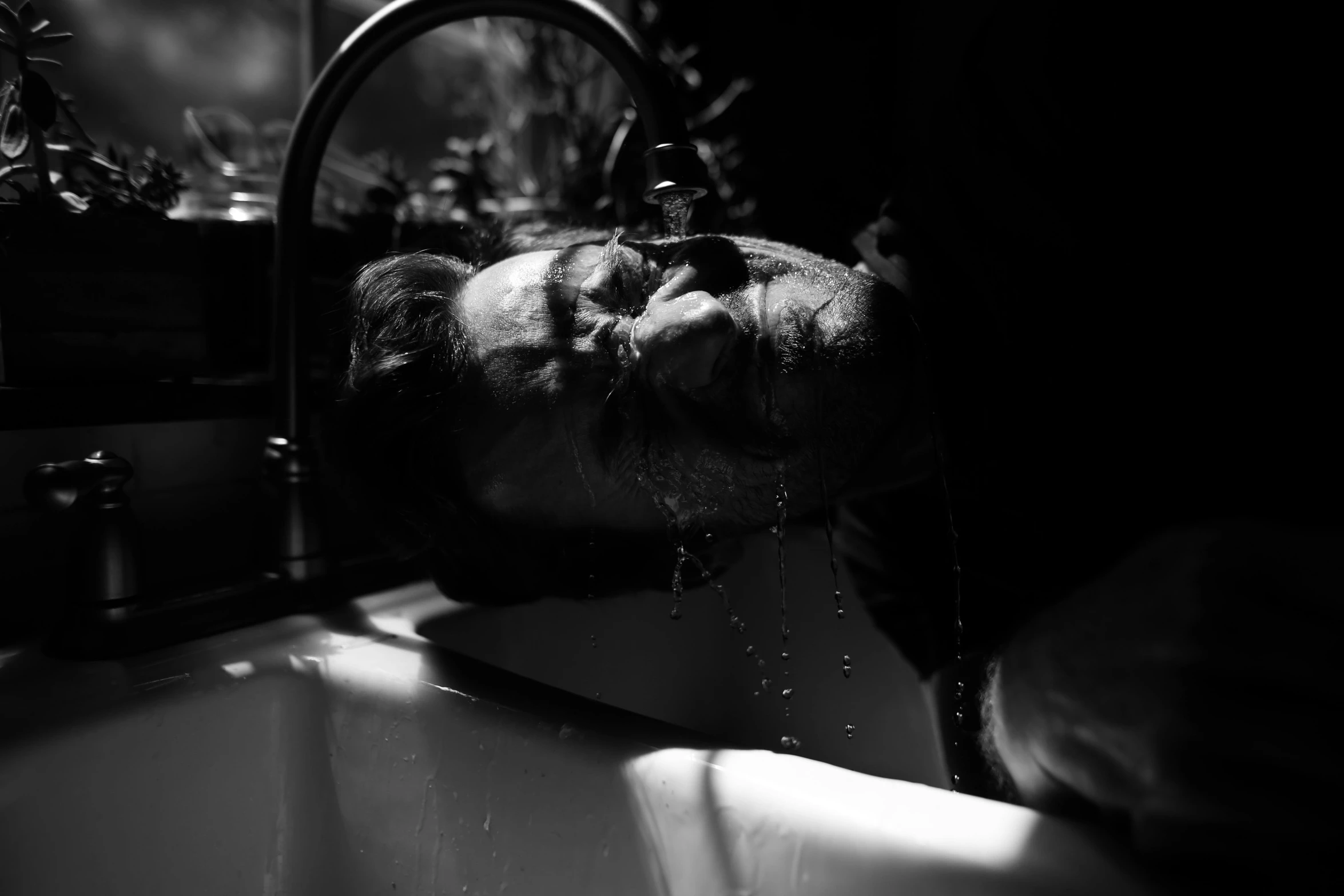 a black and white photo of a dog taking a bath, a black and white photo, by Matija Jama, unsplash, process art, light falling on face, vomiting blood, late night, sad man