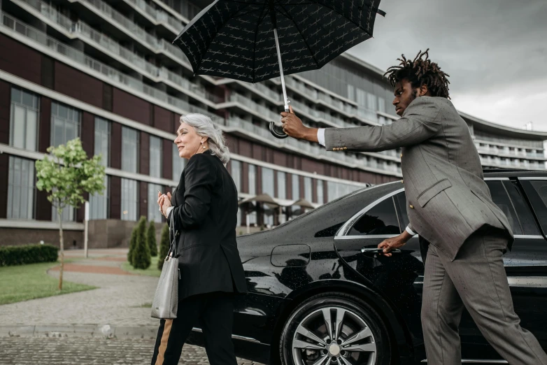 a man helping a woman out of a car with an umbrella, pexels contest winner, renaissance, wearing a black suit, black man, [ cinematic, non-binary