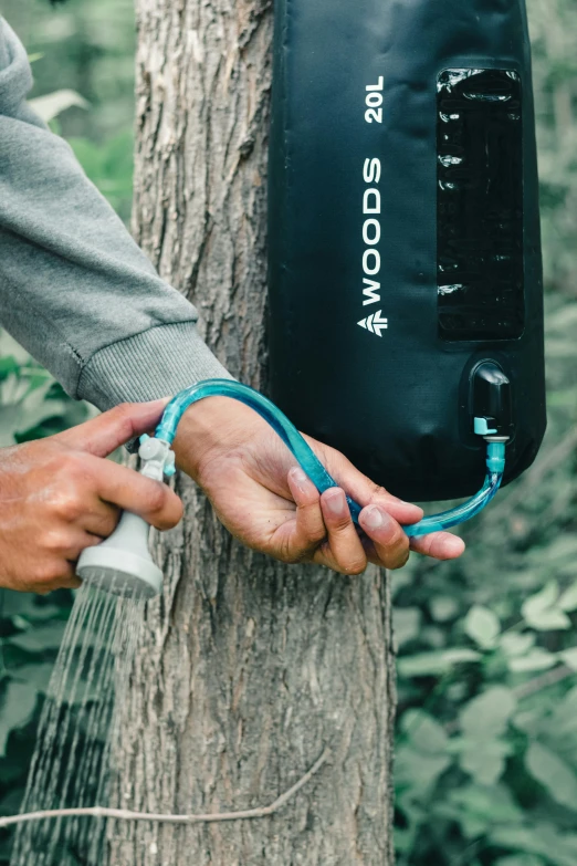 a person holding a water bottle attached to a tree, detailed product image, pods, woodlands, hoses