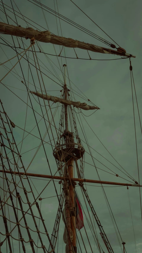 a tall ship sitting on top of a body of water, an album cover, by Elsa Bleda, pexels contest winner, renaissance, moody : : wes anderson, low detail, square, grainy picture