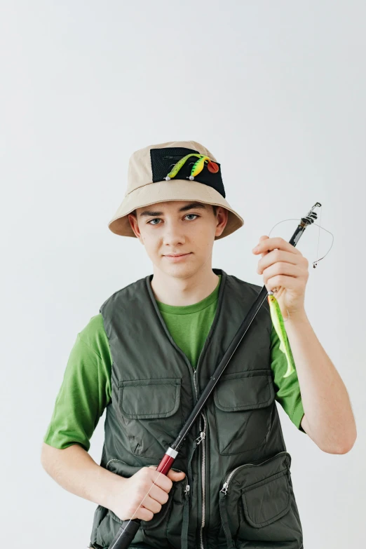 a boy in a hat holding a fishing rod, inspired by Ion Andreescu, trending on pexels, halfbody headshot, teen elf, full product shot, wearing military outfit
