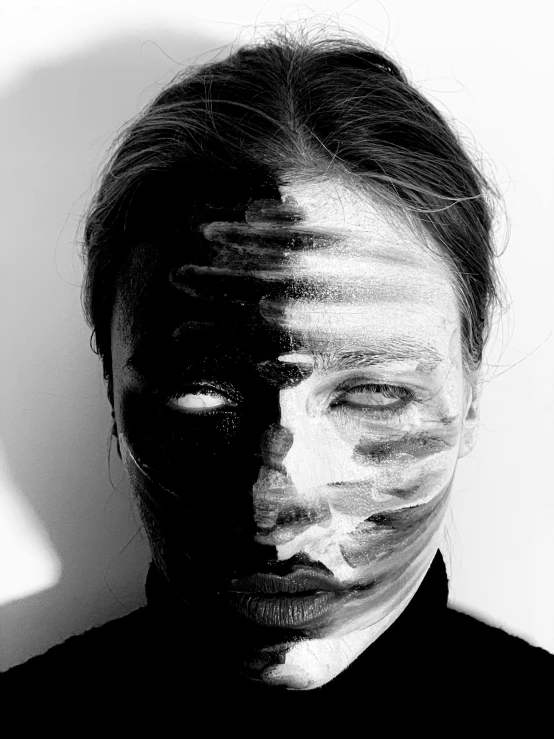 a black and white photo of a man with white paint on his face, a black and white photo, by Anna Füssli, surrealism, symmetry!! portrait of a woman, kirsi salonen, shadowy and dark, dark visor covering face