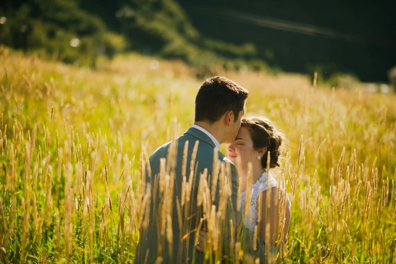 a bride and groom in a field of tall grass, by Julia Pishtar, unsplash, medium format. soft light, avatar image, tourist photo, lovely valley