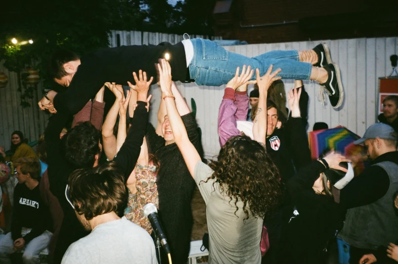 a group of people with their hands in the air, an album cover, by Anita Malfatti, unsplash, happening, backyard wrestling, at a birthday party, lying on back, an ahoge stands up on her head