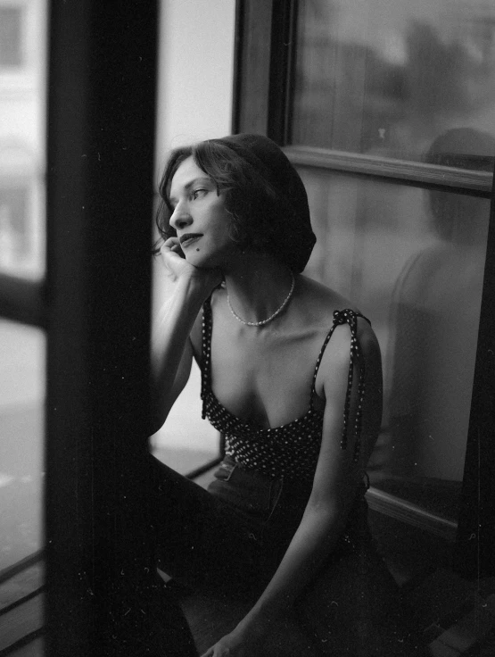 a black and white photo of a woman sitting on a window sill, inspired by Peter Lindbergh, unsplash contest winner, renaissance, with short hair, gal gadot, 35mm!!! 1990, wearing a camisole