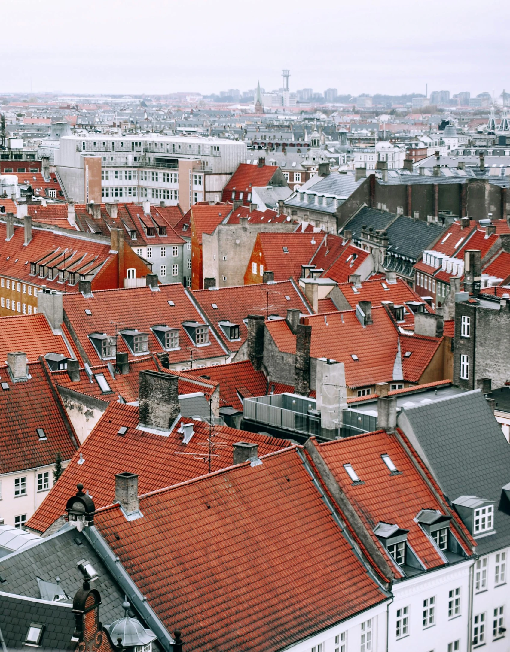 a view of a city from the top of a building, a colorized photo, pexels contest winner, baroque, denmark, red brown and grey color scheme, gif, tiled roofs