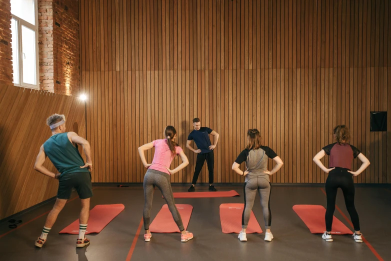 a group of people standing next to each other on yoga mats, by Anna Findlay, trending on pexels, figuration libre, train with maroon, 8 k -, melbourne, closed limbo room