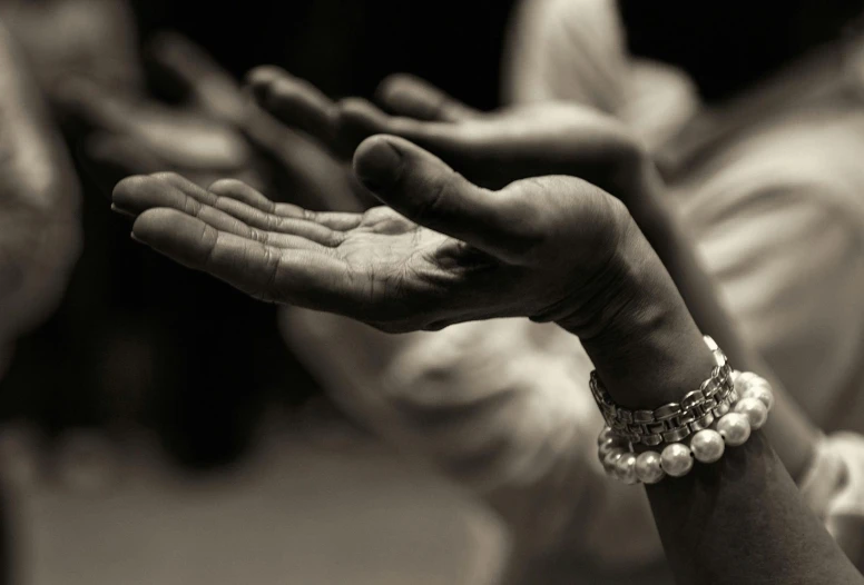 a close up of a person holding out their hands, a black and white photo, by Lucia Peka, hurufiyya, pearls, sufism, compassion, dayanita singh