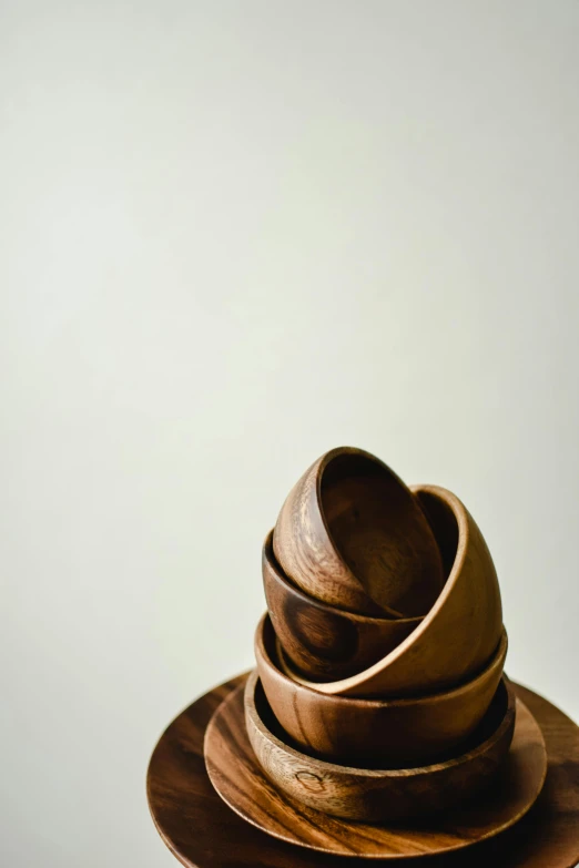 a stack of wooden bowls sitting on top of a table, plain background, taken with sony alpha 9, sculpture made of wood, chocolate