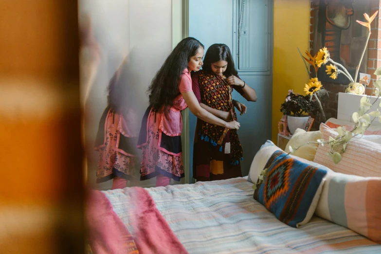 a couple of girls standing next to each other on a bed, pexels contest winner, hurufiyya, ornately dressed, still from a terence malik film, looking around a corner, woman holding another woman