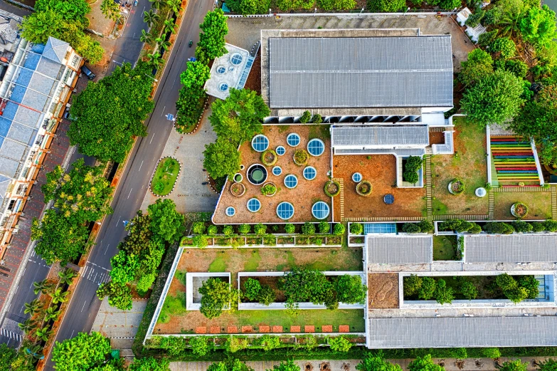 an aerial view of a building surrounded by trees, unsplash, bengal school of art, roof garden, panoramic shot, hydroponic farms, brown