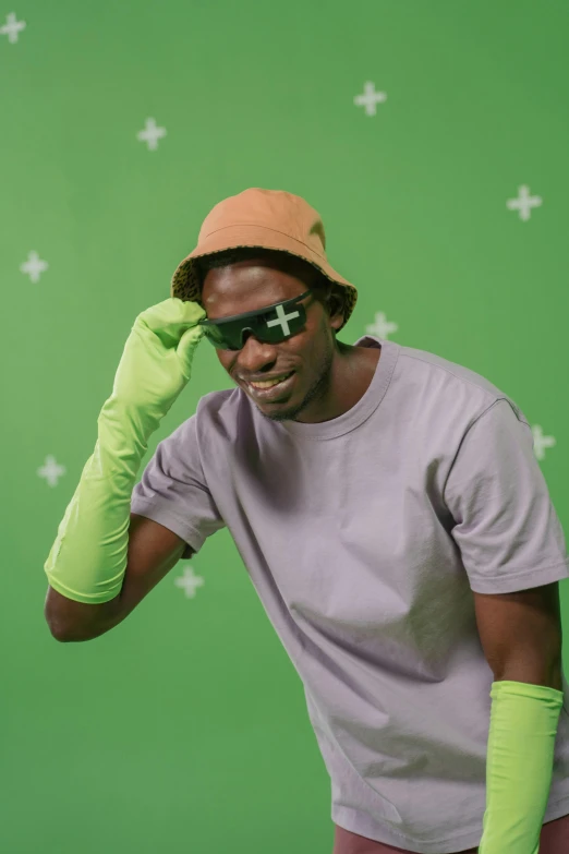 a man wearing green gloves and a hat, trending on pexels, afrofuturism, discord profile picture, playful pose, homestuck, blind brown man