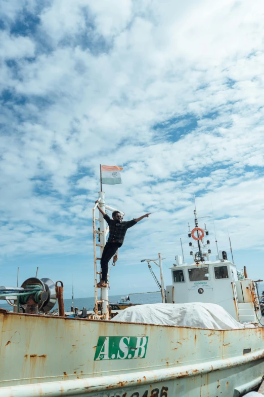 a man standing on top of a boat in the water, a statue, by Hannah Tompkins, unsplash, happening, waving and smiling, indonesia, shipyard, leaping with arms up