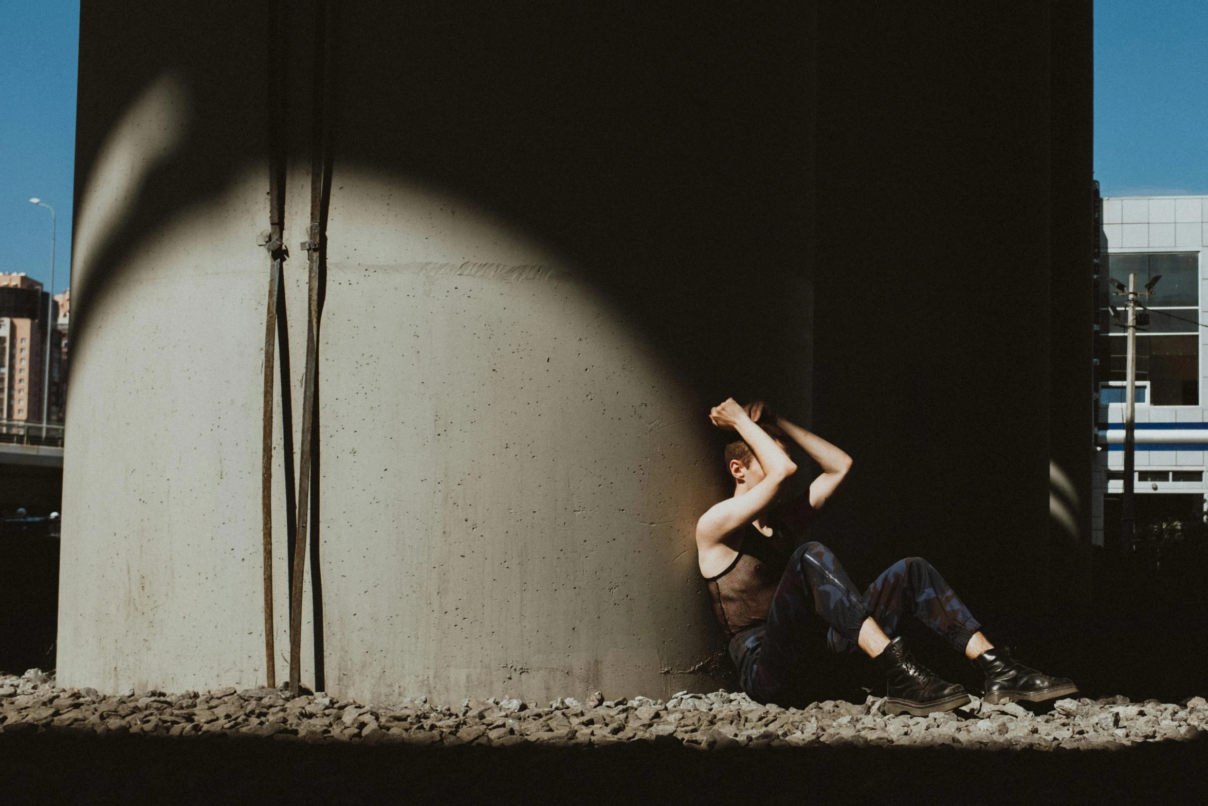 a woman sitting on top of a cement wall, inspired by Elsa Bleda, pexels contest winner, crawling out of a dark room, frustrated, photo of a man, background image