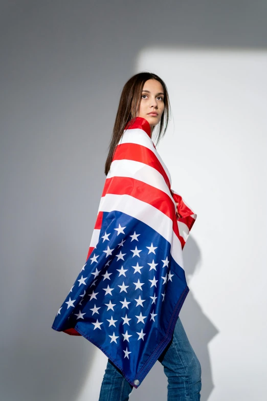 a woman wrapped in an american flag blanket, inspired by Christen Dalsgaard, shutterstock contest winner, pop art, wearing a luxurious silk cloak, isabela moner, official product photo, on white