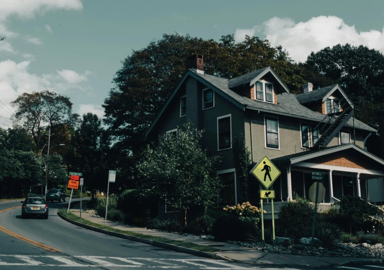 a large house sitting on the side of a road, unsplash, traffic signs, cornell, background image