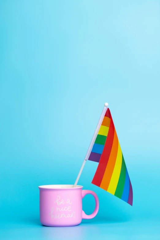 a cup with a rainbow flag sticking out of it, a photo, shutterstock, pastel colored, pink, can, diverse