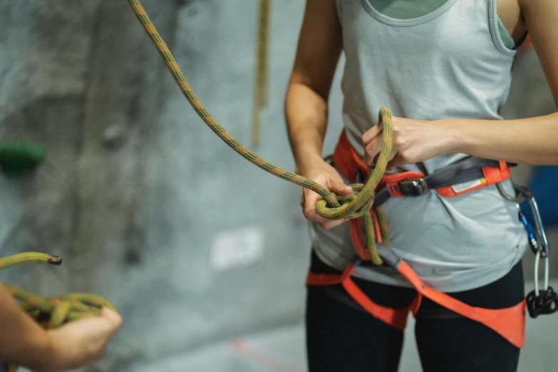 a woman holding a rope while standing next to another woman, trending on pexels, belaying, worksafe. instagram photo, teaser, high angle