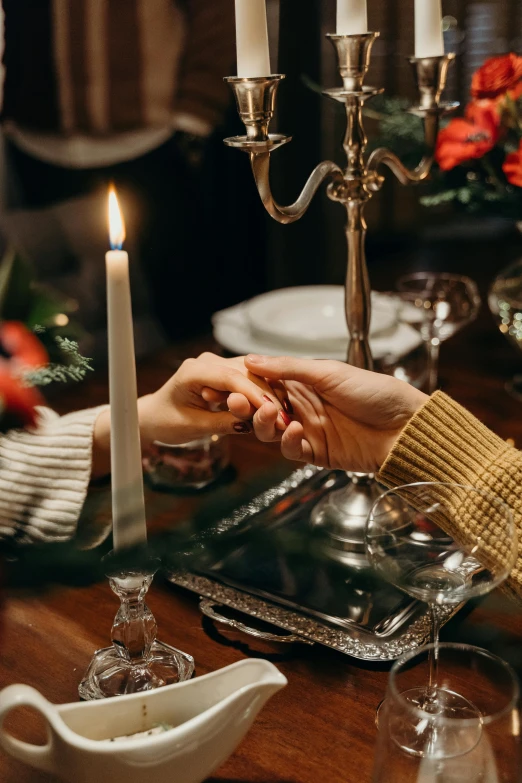 a man and a woman holding hands at a dinner table, pexels contest winner, romanticism, white candles, winter, old hollywood themed, instagram post