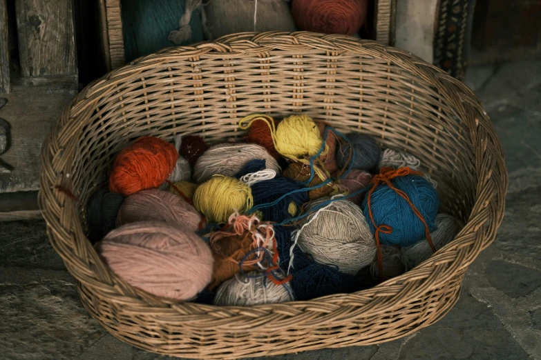 a wicker basket filled with balls of yarn, unsplash, 1960s color photograph, miscellaneous objects, volumetric wool felting, alessio albi