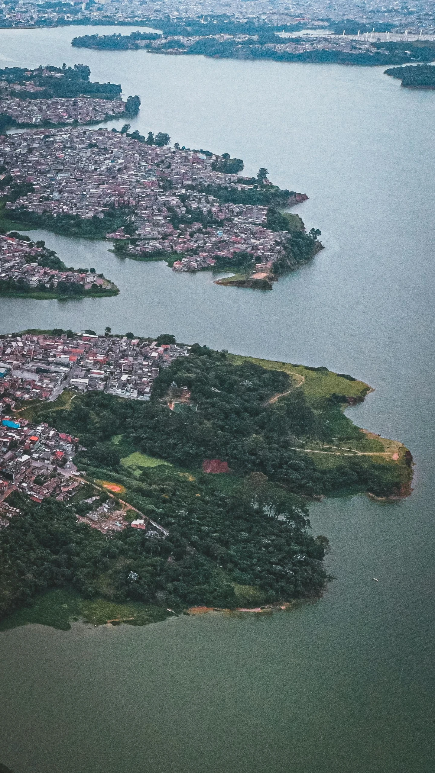 an aerial view of a large body of water, by Daniel Lieske, pexels, city of the jungle, in the foreground a small town, thumbnail, 8k detail