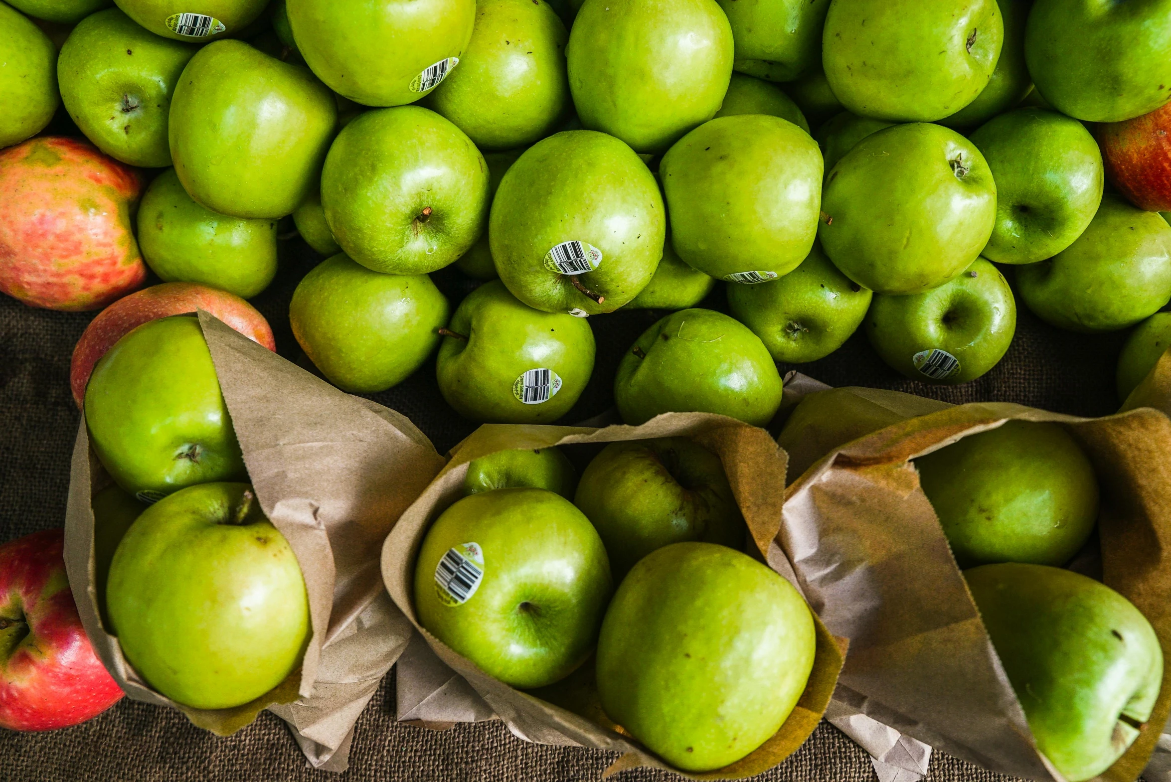 a pile of green apples sitting on top of a table