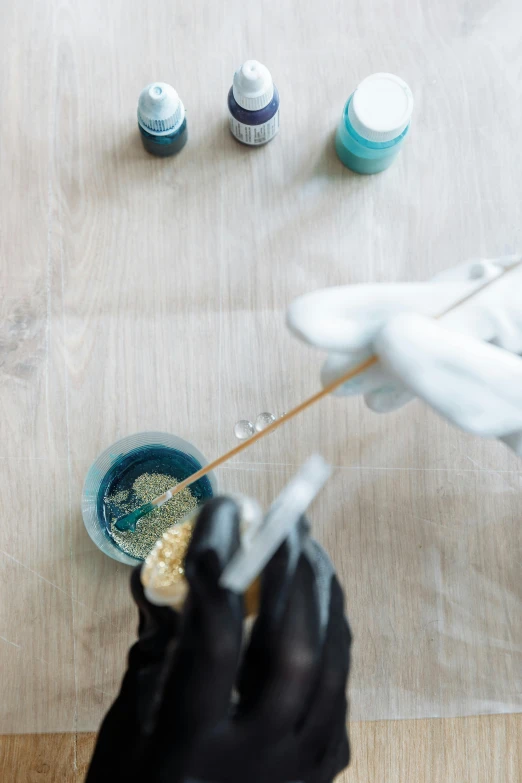 a close up of a person holding a toothbrush, potions, acid pooling on the floor, gold and silver ink, beakers