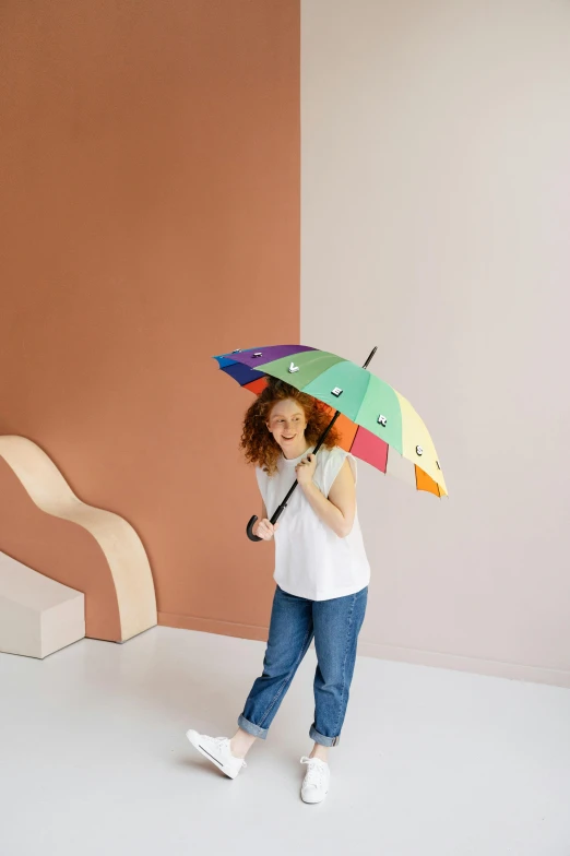 a woman standing in a room holding a colorful umbrella, inspired by Okuda Gensō, solid colours material, medium - shot, for kids, dragonfly-shaped