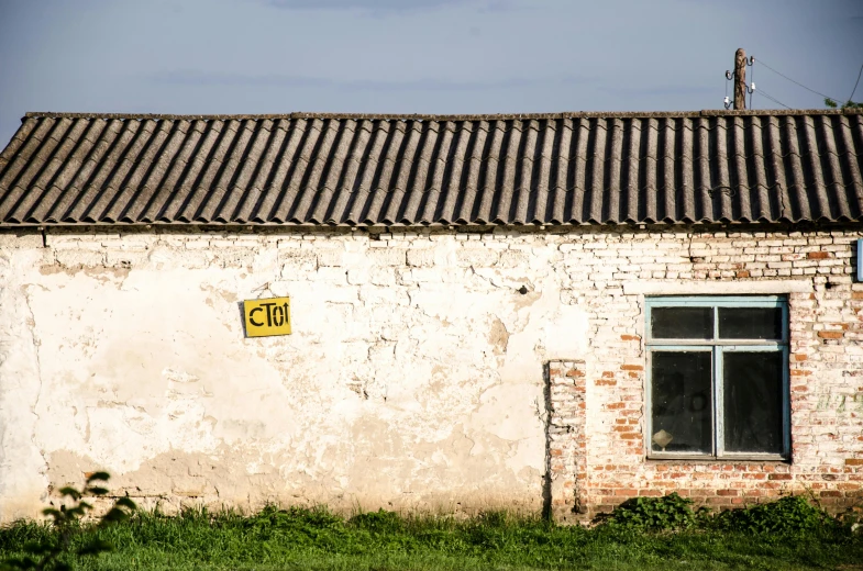 a sign that is on the side of a building, a picture, by Jan Tengnagel, unsplash, rural, background image, soviet architecture, farmhouse