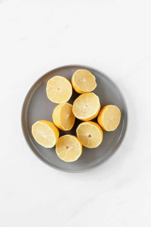 a plate of sliced lemons on a white surface, lumi, 6 pack, grey mist, round-cropped