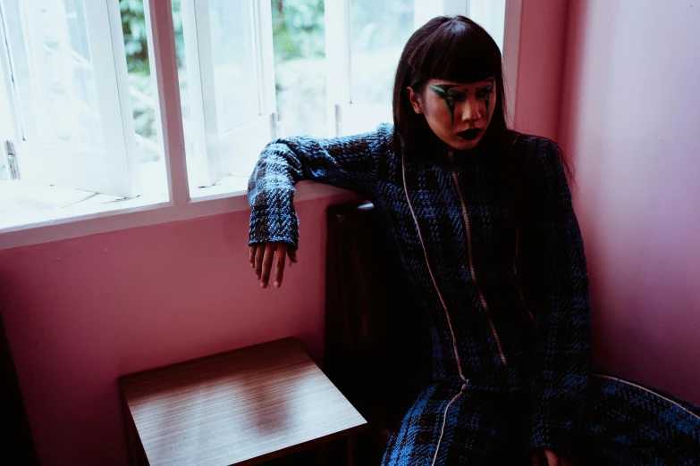 a woman sitting on a chair in front of a window, an album cover, unsplash, private press, gemma chan girl portrait, blue checkerboard dress, wearing jacket and skirt, wearing atsuko kudo latex outfit