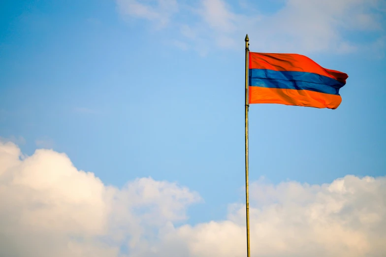 an orange and blue flag flying high in the sky, inspired by Arthur Sarkissian, hurufiyya, square, georgic, thai, pink and orange