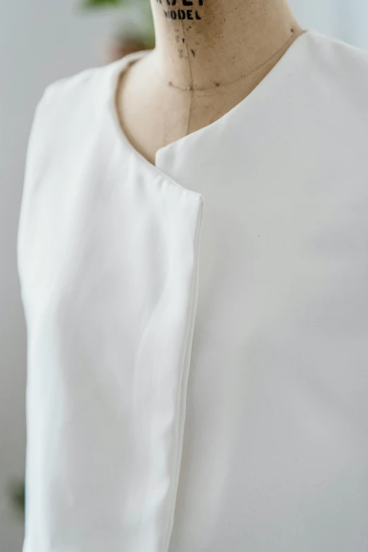 a woman with a tattoo on her neck, inspired by Georgia O'Keeffe, simple cream dress, closeup - view, tonal topstitching, white top