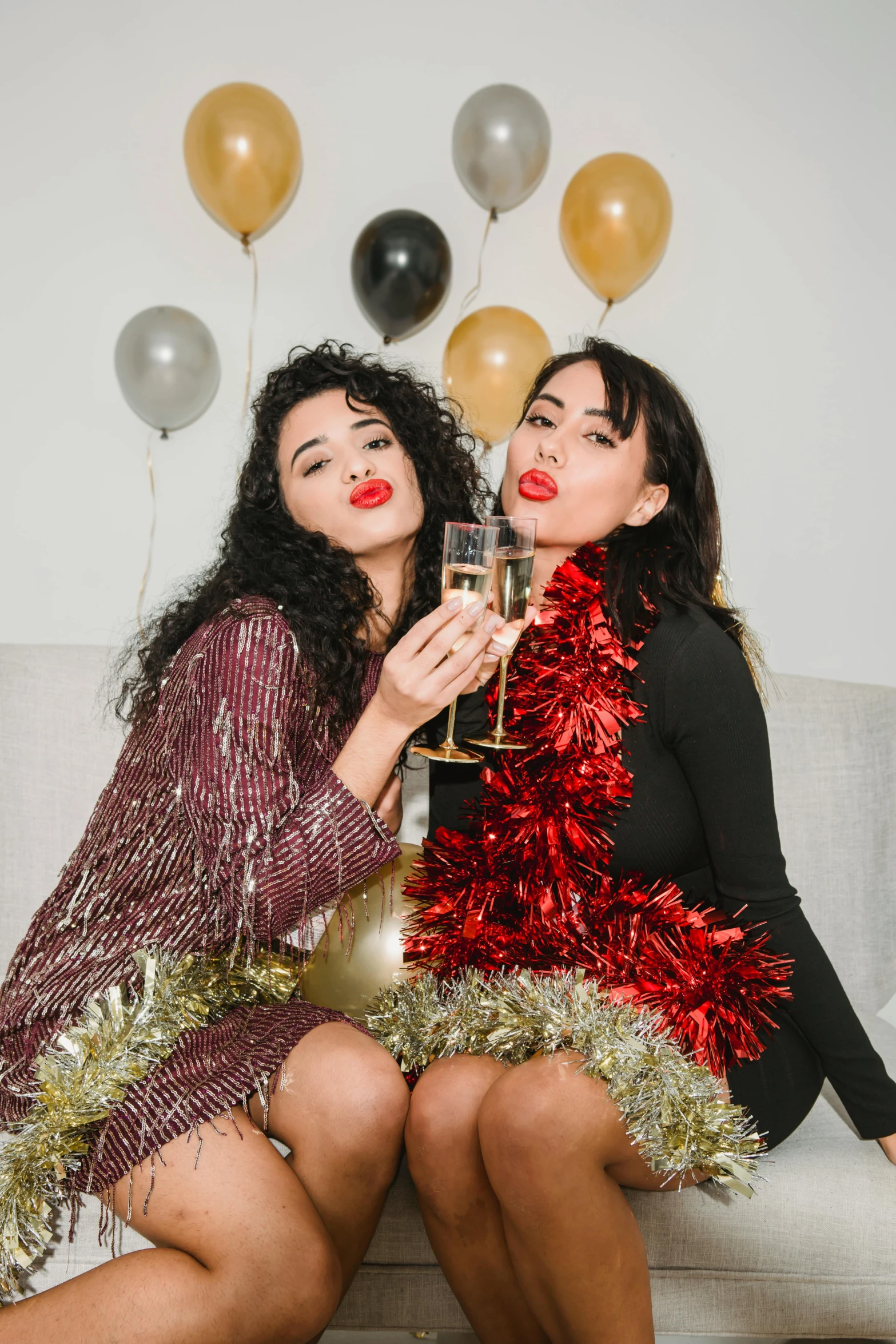 two women sitting on a couch drinking champagne, trending on pexels, happening, wearing festive clothing, thick red lips, glitter gif, party balloons