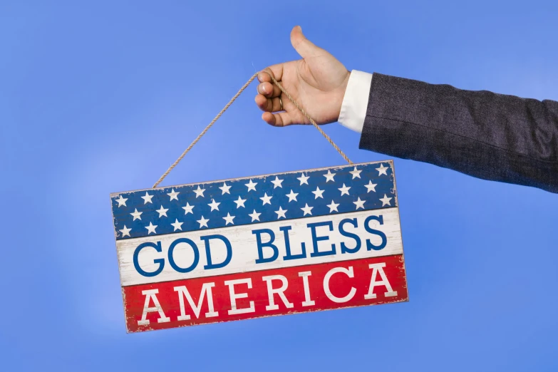 a hand holding a sign that says god bless america, by Carey Morris, shutterstock, american romanticism, uk, g 7 summit, thumbnail, decoration