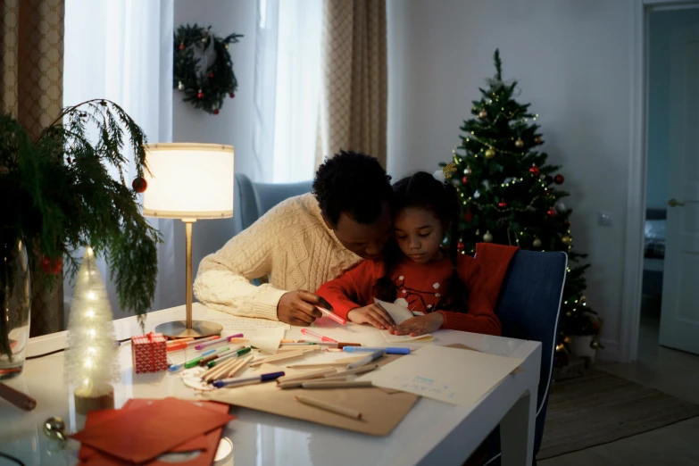 a woman and child sitting at a table in front of a christmas tree, a child's drawing, pexels contest winner, visual art, mid morning lighting, gif, low lighting, writing a letter