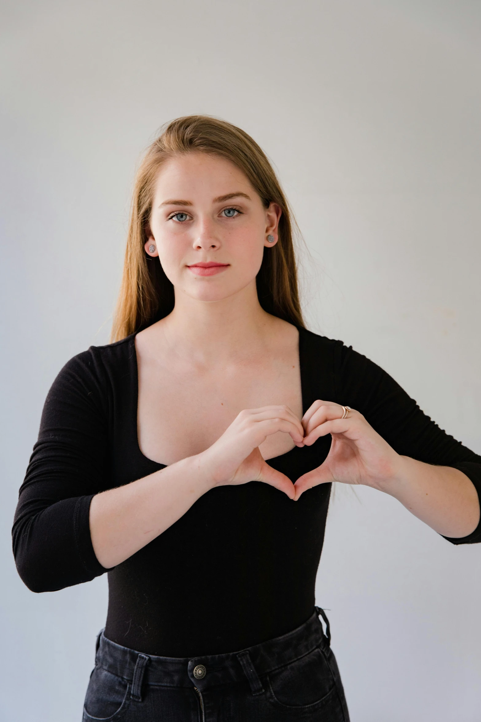 a woman making a heart with her hands, by Gavin Hamilton, acting headshot, 19-year-old girl, mia kischner, shoulder - length