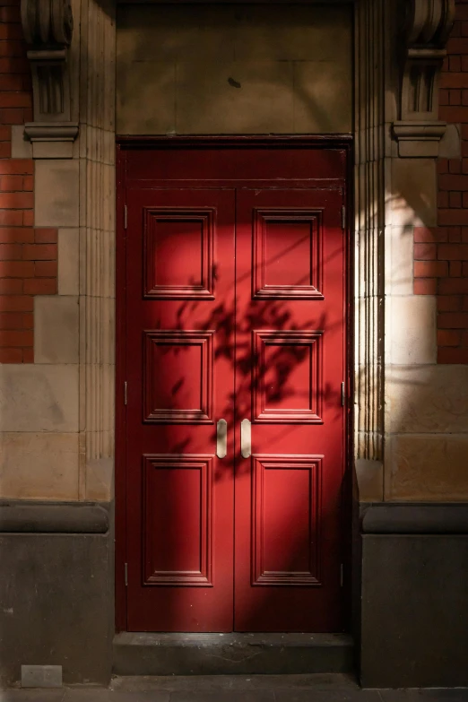 a red door in front of a brick building, australian tonalism, peter guthrie, backlit, brown, red