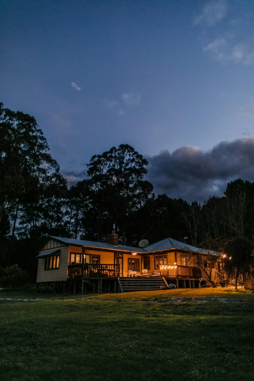 a house sitting on top of a lush green field, by Jessie Algie, unsplash contest winner, australian tonalism, dimly lit cozy tavern, torchlit, blue sky, front and side view