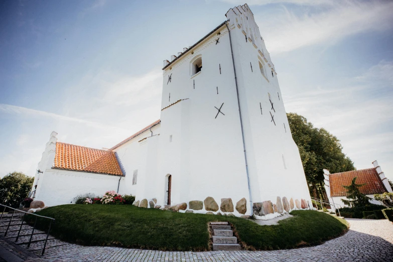 a large white building sitting on top of a lush green field, a picture, by Jesper Knudsen, unsplash, romanesque, wedding, anato finnstark. front view, tower, 1990's photo