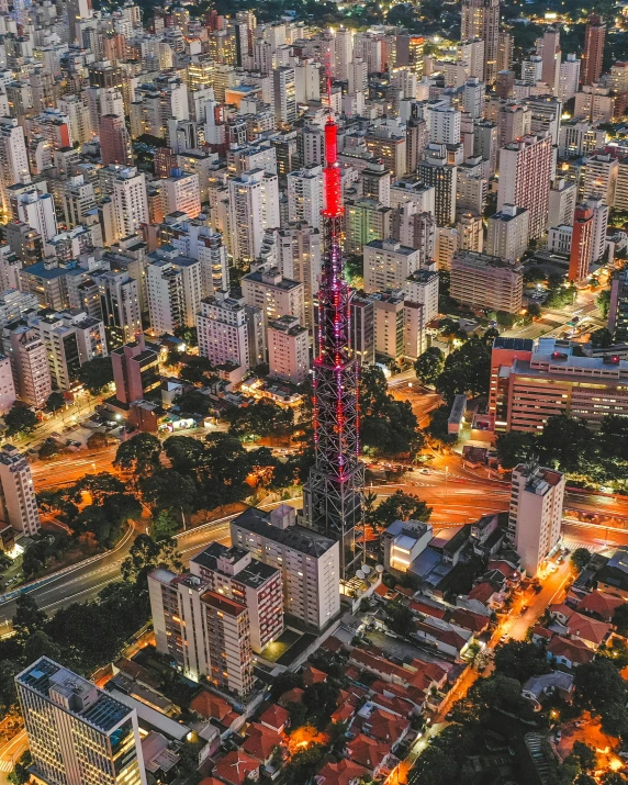 an aerial view of a city at night, an album cover, by Matteo Pérez, pexels contest winner, bolsonaro, tower, panorama, red building