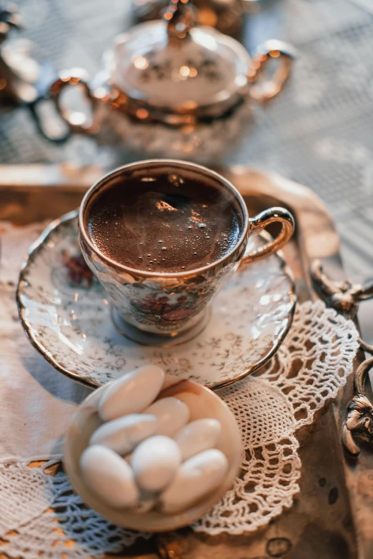 a cup of hot chocolate and marshmallows on a tray, by Lucia Peka, pexels contest winner, baroque, turkey, victorian setting, 💣 💥💣 💥, bronze