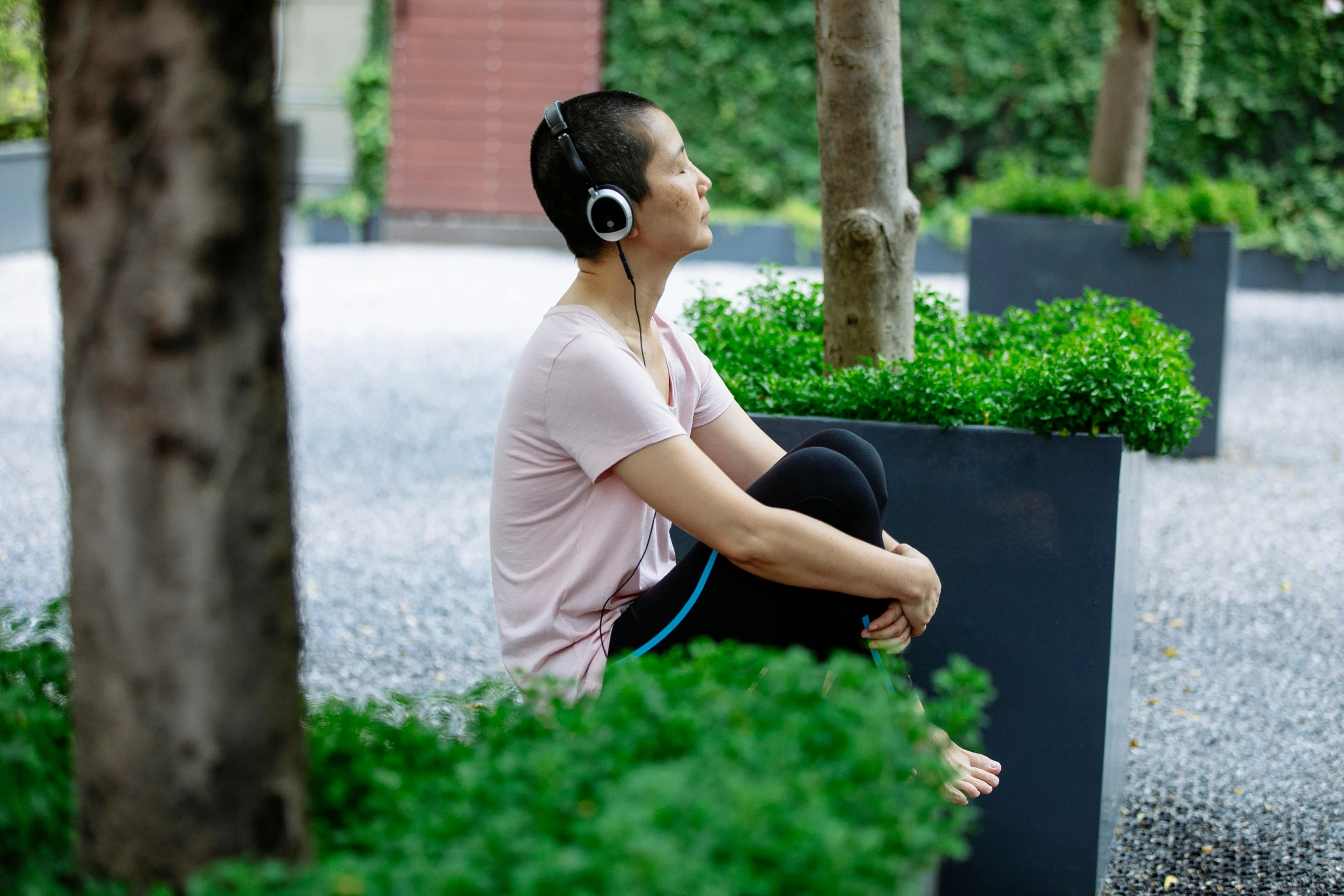 a woman sitting on a bench with headphones on, inspired by Fei Danxu, unsplash, happening, healing pods, in an eco city, vietnamese woman, profile image