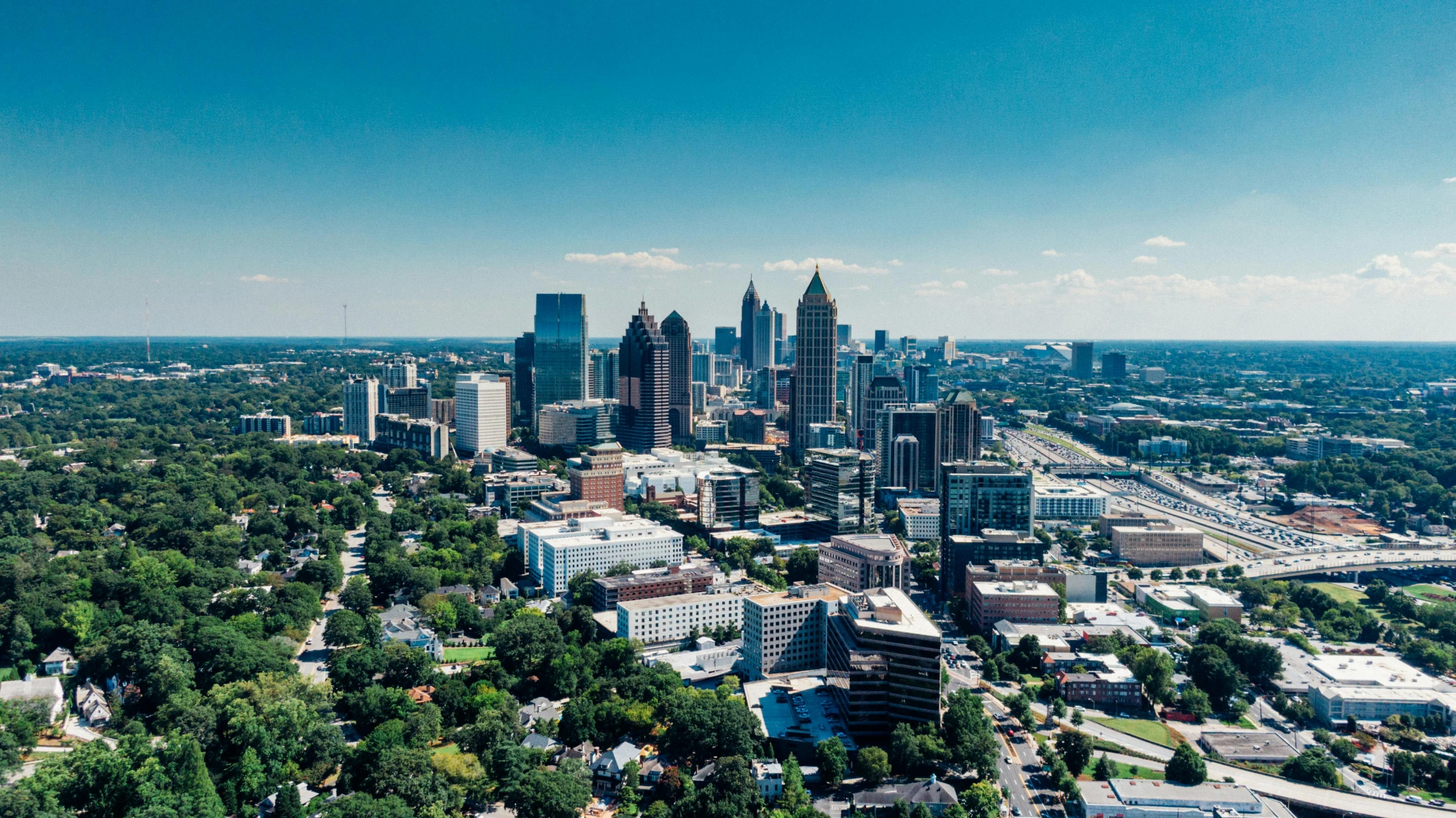 a city with tall buildings and trees in the foreground, by Dr. Atl, pexels contest winner, hurufiyya, aerial footage, sunny day time, cinematic shot ar 9:16 -n 6 -g, alabama