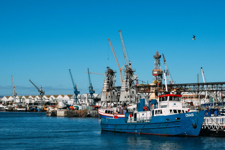 a number of boats in a body of water, by Tom Wänerstrand, pexels contest winner, hurufiyya, industrial photography, blue sky, harbour, south african coast