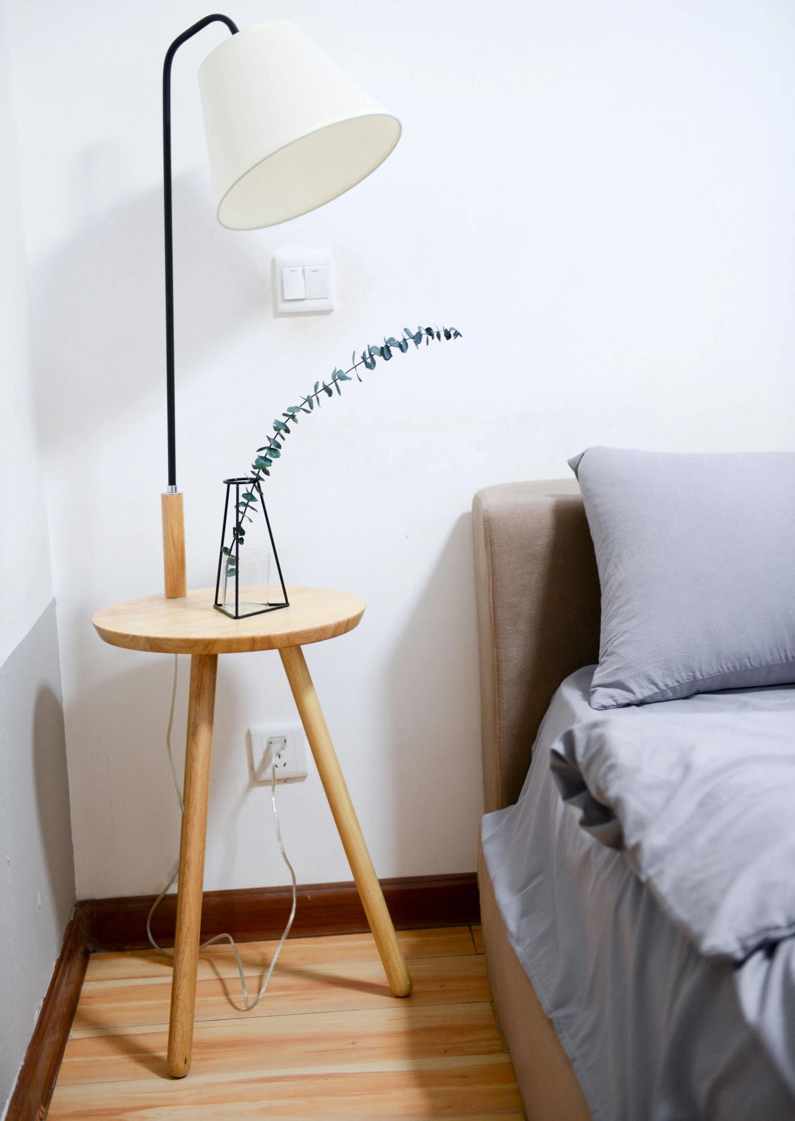 a lamp sitting on top of a wooden table next to a bed, detailed product image, electrical, eucalyptus, mixed art