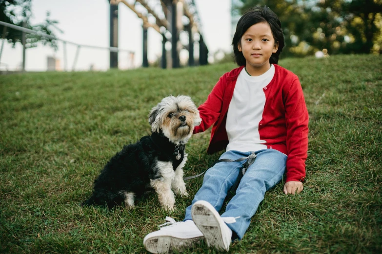 a little girl sitting in the grass with a dog, pexels contest winner, asian male, thumbnail, fashionable, small dog