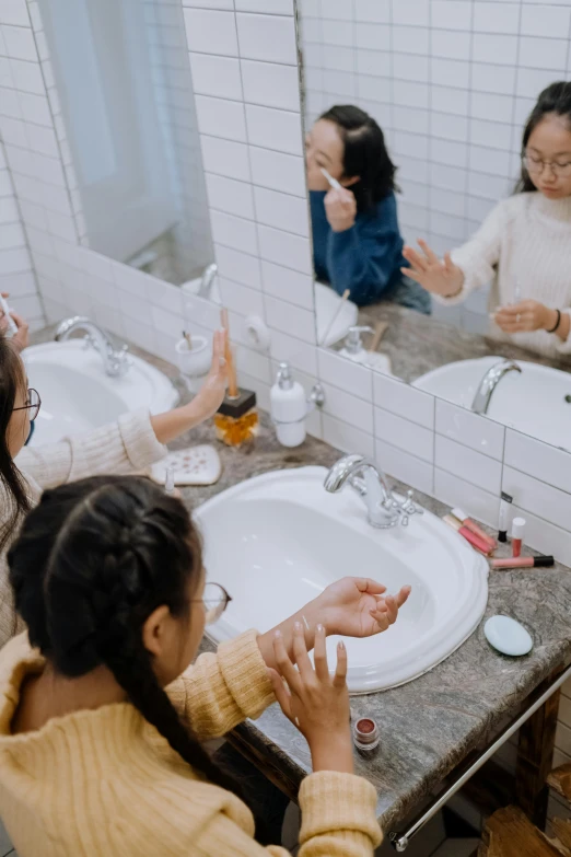 a group of women washing their hands in a bathroom, pexels contest winner, happening, young asian girl, reaching out to each other, kids playing, mirrored